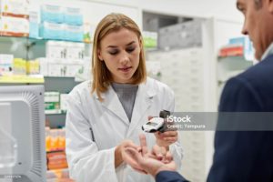 A young female pharmacist doing a diabetes sugar test to a patient